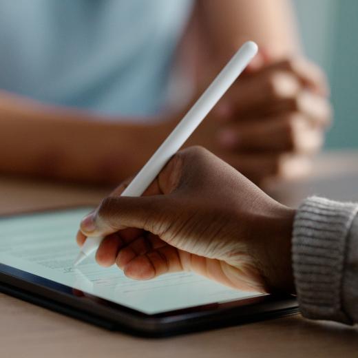 Eine Person schreibt auf einem Tablet